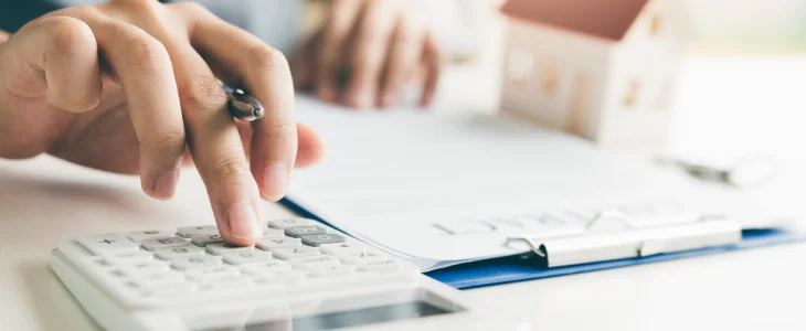 Man calculating his fixed rate and adjustable rate on his refinance loans