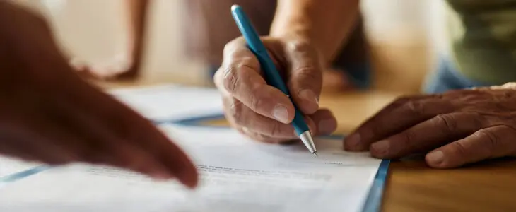 Close up of unrecognizable person signing a contract in the office.